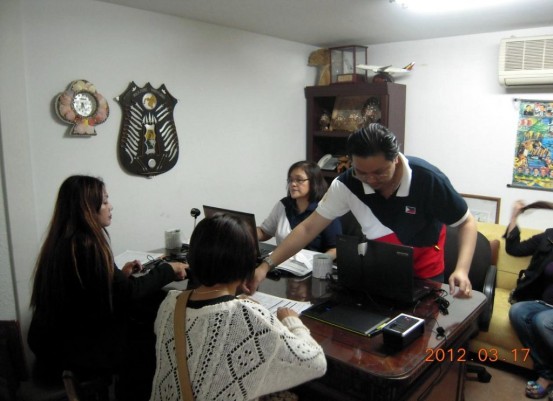 (Okinawa, Japan) Embassy personnel as VRM operators assist two Filipinas in their registration.